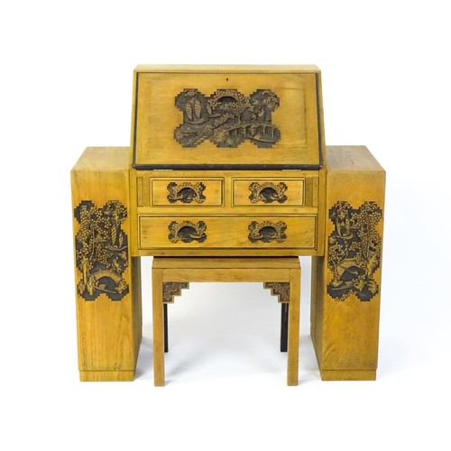 1547 - An early / mid 20thC Teak bureau accompanied by a stool, with carved oriental scenes to the front, d... 