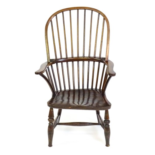 1556 - A 19thC double bow back Windsor chair, having a stick back, swept arms, a shaped seat and raised on ... 