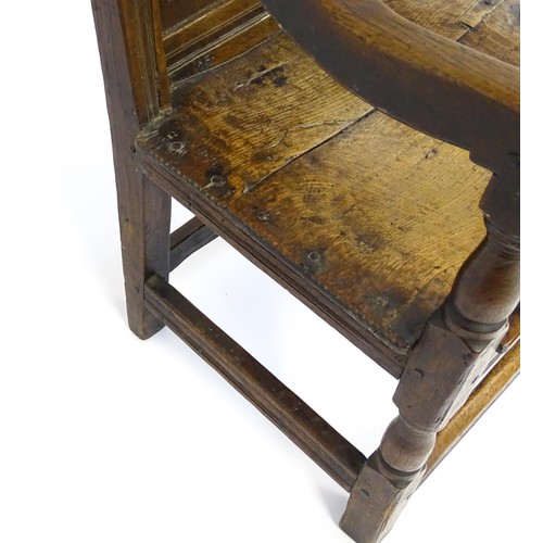 1558 - A 17thC oak Wainscot chair with a panelled, carved backrest above shaped arms and an incised frame, ... 