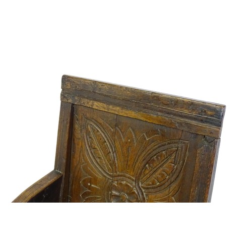 1558 - A 17thC oak Wainscot chair with a panelled, carved backrest above shaped arms and an incised frame, ... 