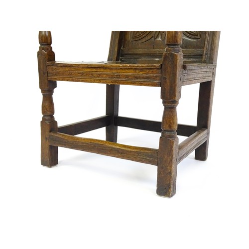 1558 - A 17thC oak Wainscot chair with a panelled, carved backrest above shaped arms and an incised frame, ... 