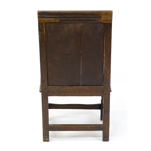 1558 - A 17thC oak Wainscot chair with a panelled, carved backrest above shaped arms and an incised frame, ... 