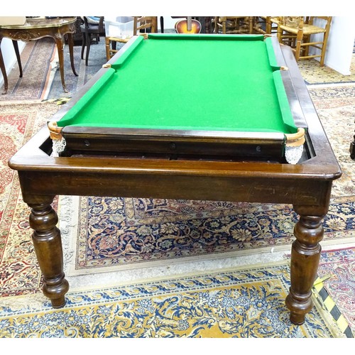 1559 - A 20thC oak combination dining / snooker table, with revolving mechanism and slate base, approx 84 1... 