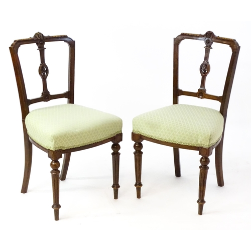 1609 - A pair of Edwardian walnut side chairs with carved cresting rails, pierced floral back splats and ra... 