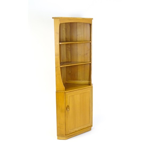 1628 - Vintage / Retro: An elm Ercol Windsor corner cabinet with a moulded cornice above three shelves and ... 