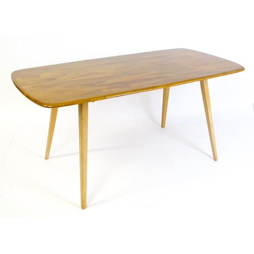 1631 - Vintage / Retro: An Ercol dining table with an oblong elm top above four tapering splayed legs. Bear... 