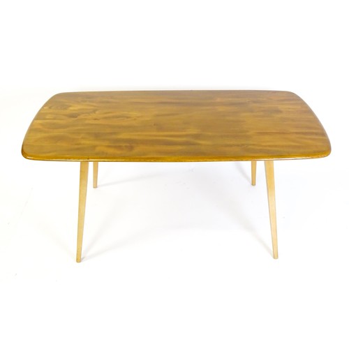 1631 - Vintage / Retro: An Ercol dining table with an oblong elm top above four tapering splayed legs. Bear... 