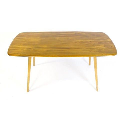 1631 - Vintage / Retro: An Ercol dining table with an oblong elm top above four tapering splayed legs. Bear... 