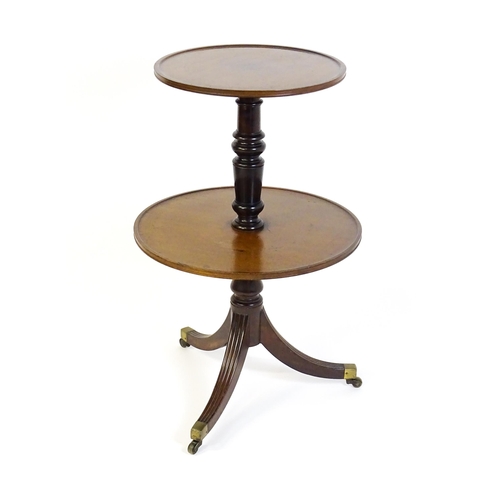 1451 - A mid 19thC two tier mahogany dumb waiter, with two circular dished platforms on a turned tapering p... 