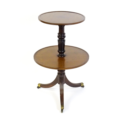 1451 - A mid 19thC two tier mahogany dumb waiter, with two circular dished platforms on a turned tapering p... 