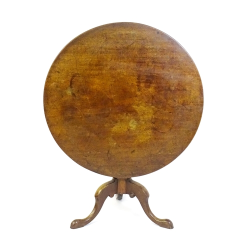 1464 - An 18thC mahogany tripod table with a one plank top, the table with a turned tapering pedestal and r... 