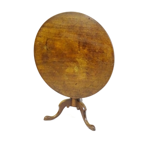 1464 - An 18thC mahogany tripod table with a one plank top, the table with a turned tapering pedestal and r... 