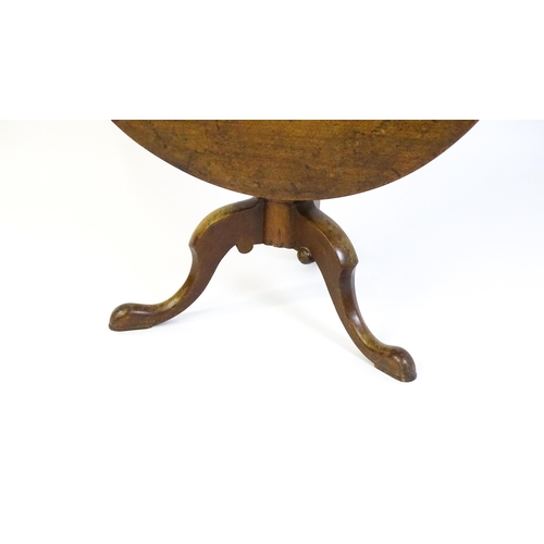 1464 - An 18thC mahogany tripod table with a one plank top, the table with a turned tapering pedestal and r... 