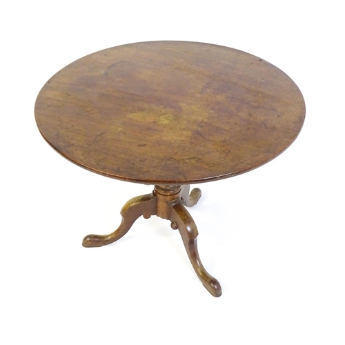 1464 - An 18thC mahogany tripod table with a one plank top, the table with a turned tapering pedestal and r... 