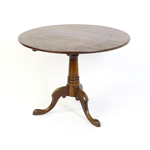 1464 - An 18thC mahogany tripod table with a one plank top, the table with a turned tapering pedestal and r... 