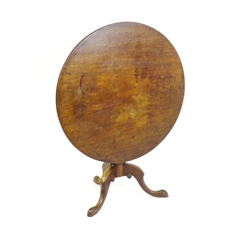 1464 - An 18thC mahogany tripod table with a one plank top, the table with a turned tapering pedestal and r... 