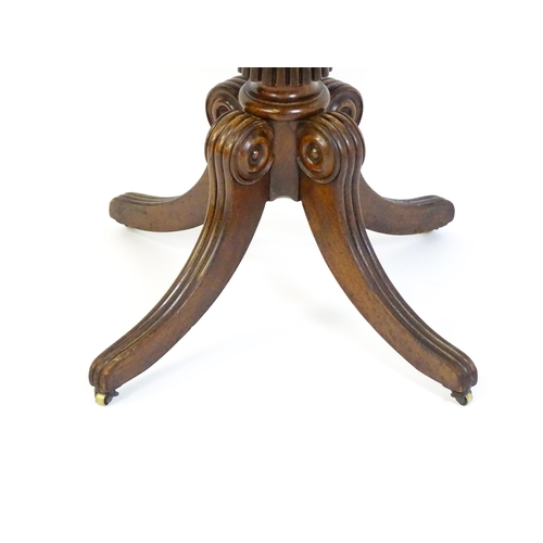 1545 - A 19thC mahogany occasional table, with a reeded tapering pedestal and raised on four reeded legs wi... 