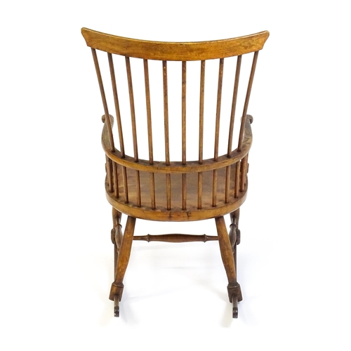 1546 - A mid 19thC ash and sycamore Windsor rocking chair, with a bowed top rail, tuned spindles and a shap... 