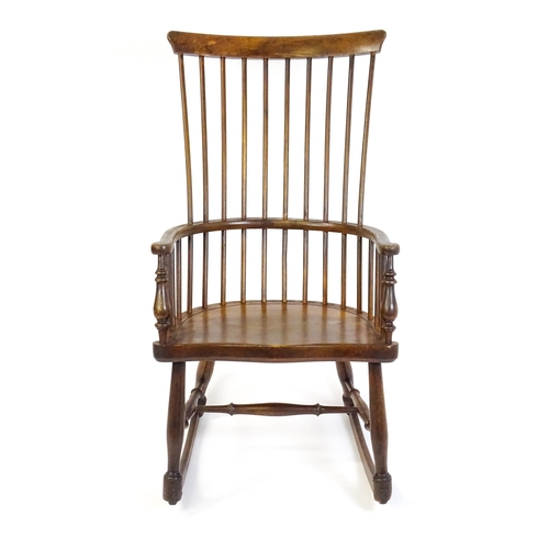 1546 - A mid 19thC ash and sycamore Windsor rocking chair, with a bowed top rail, tuned spindles and a shap... 