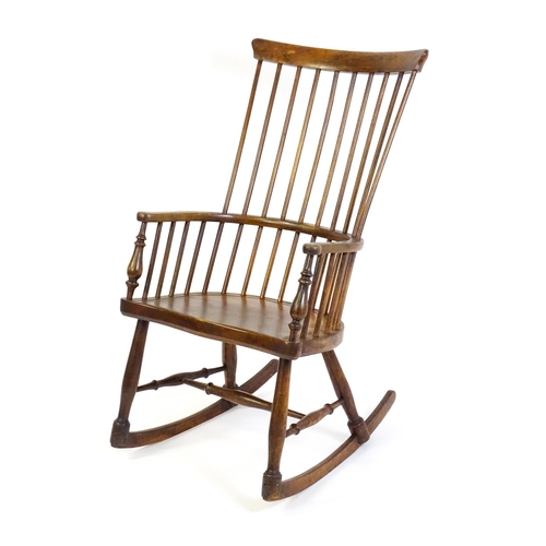 1546 - A mid 19thC ash and sycamore Windsor rocking chair, with a bowed top rail, tuned spindles and a shap... 