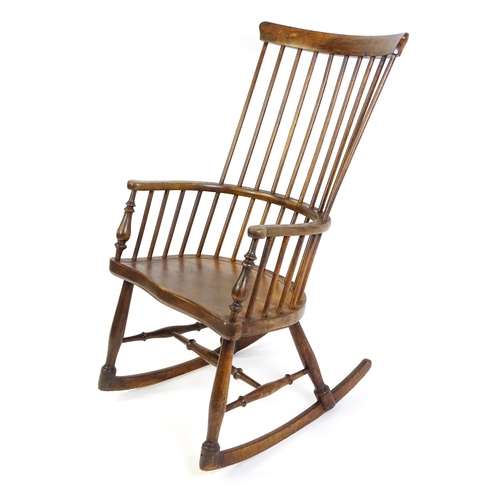 1546 - A mid 19thC ash and sycamore Windsor rocking chair, with a bowed top rail, tuned spindles and a shap... 