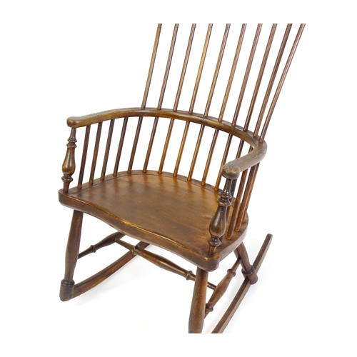 1546 - A mid 19thC ash and sycamore Windsor rocking chair, with a bowed top rail, tuned spindles and a shap... 