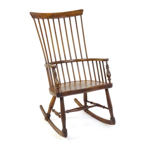 1546 - A mid 19thC ash and sycamore Windsor rocking chair, with a bowed top rail, tuned spindles and a shap... 