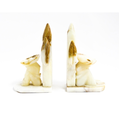 1100 - A pair of 20thC carved alabaster bookends modelled as a seated Mexican wearing a sombrero  with a ca... 