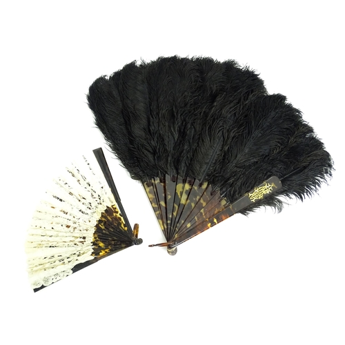 1119 - An early 20thC black feather fan with 20 faux tortoiseshell sticks. Together with another smaller ex... 