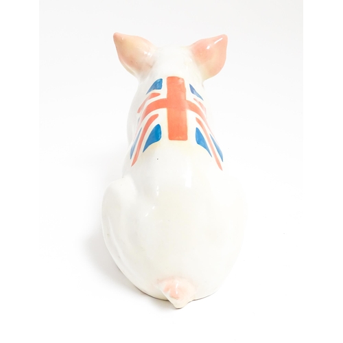 1131 - A 20thC butcher's advertising ceramic model of a seated pig with painted features and Union Jack fla... 