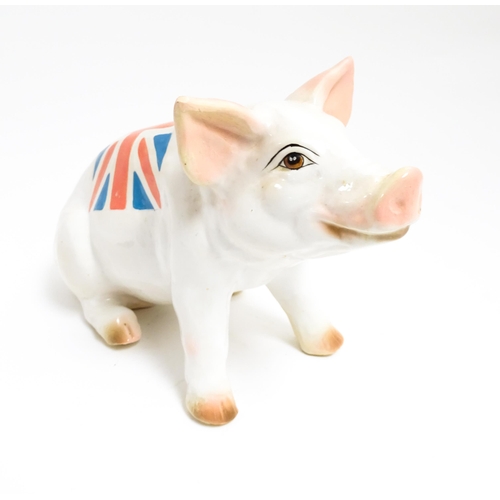 1131 - A 20thC butcher's advertising ceramic model of a seated pig with painted features and Union Jack fla... 