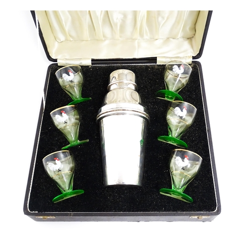 1145 - A cased Art Deco cocktail set comprising a silver plate cocktail shaker with six green footed glasse... 