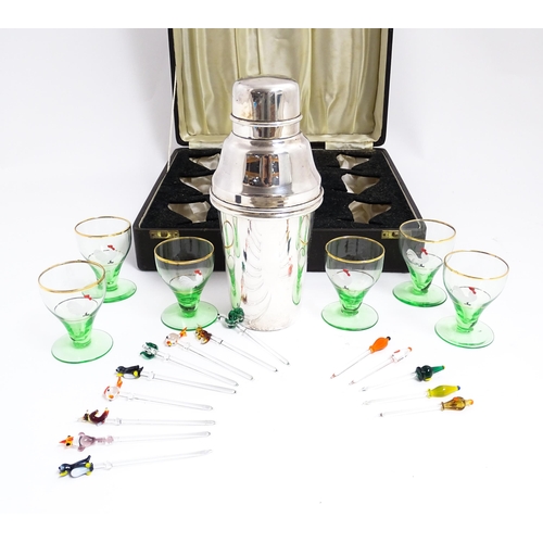 1145 - A cased Art Deco cocktail set comprising a silver plate cocktail shaker with six green footed glasse... 