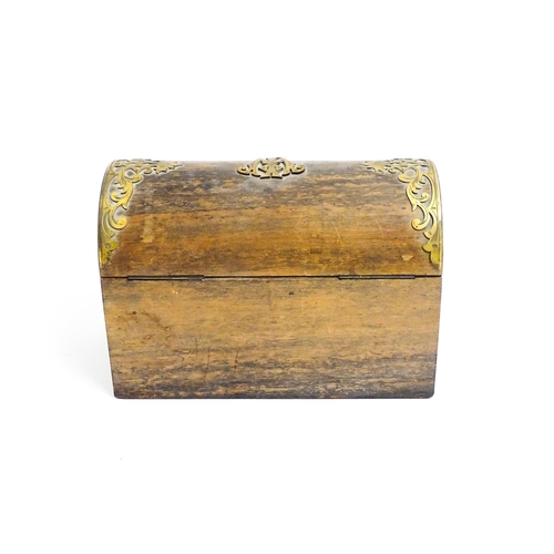 1156 - A Victorian walnut dome top caddy / casket with scrolling brass mounts. Approx. 6 1/4