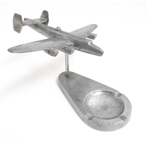 1173 - A 20thC cast ashtray surmounted by a model of an aeroplane. Approx. 4 3/4