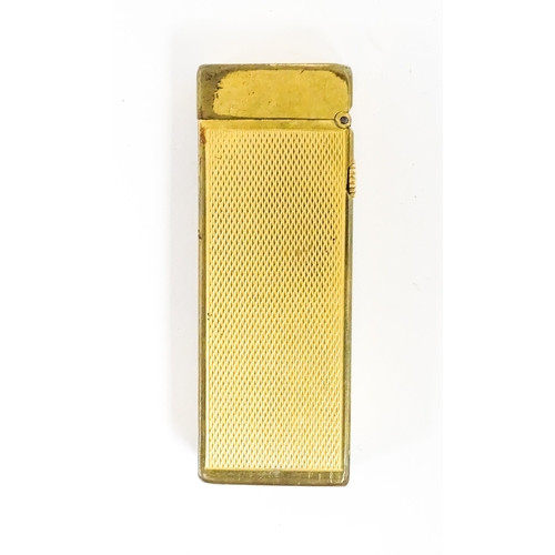 1177 - A Dunhill Rollagas lighter with chequered finish. Together with an Oriental enamelled aide de memoir... 