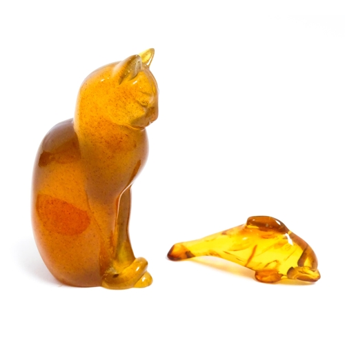 1210 - A 20thC carved amber model of a seated cat, indistinctly signed under. Together with an amber model ... 