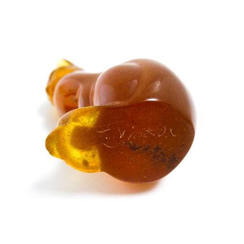 1210 - A 20thC carved amber model of a seated cat, indistinctly signed under. Together with an amber model ... 