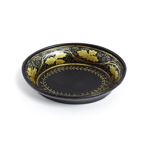 1233 - A 19thC lacquered papier mache pin dish of oval form with gilt scrolling vine decoration. Approx. 4 ... 