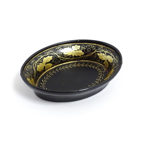 1233 - A 19thC lacquered papier mache pin dish of oval form with gilt scrolling vine decoration. Approx. 4 ... 