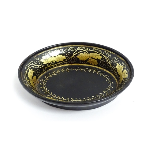 1233 - A 19thC lacquered papier mache pin dish of oval form with gilt scrolling vine decoration. Approx. 4 ... 