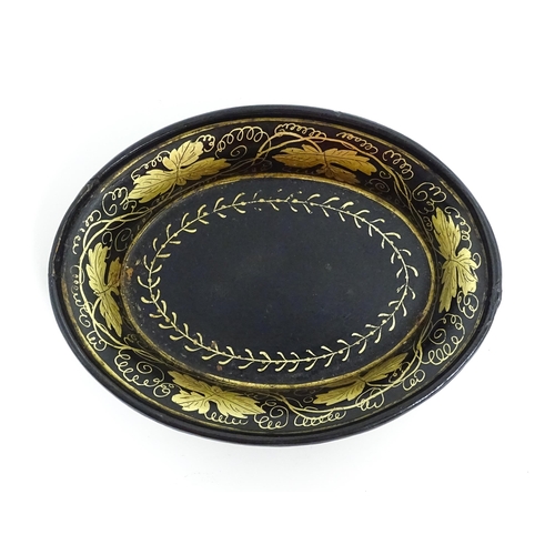 1233 - A 19thC lacquered papier mache pin dish of oval form with gilt scrolling vine decoration. Approx. 4 ... 