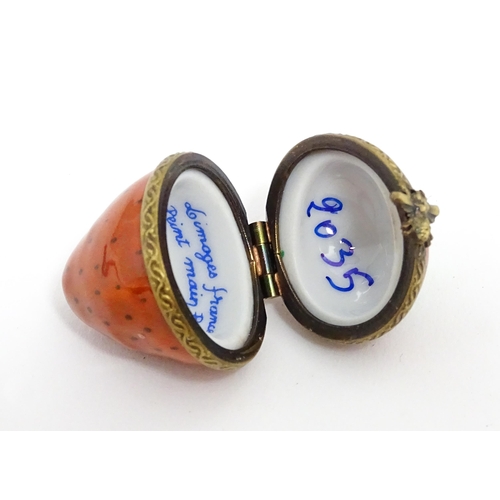 1235 - A Limoges pill box modelled as a strawberry with hinged lid, gilt mounts and insect clasp. Marked wi... 