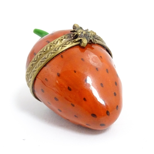 1235 - A Limoges pill box modelled as a strawberry with hinged lid, gilt mounts and insect clasp. Marked wi... 