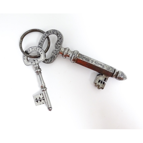 1237 - Two late 19th / early 20thC advertising keys by C. Smith & Sons the larger with engraved foliate dec... 