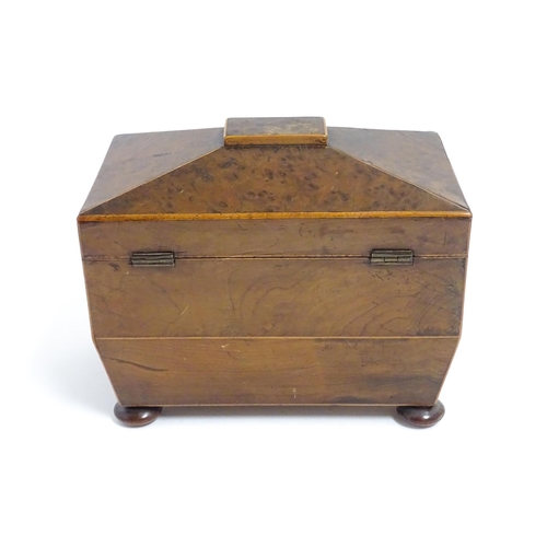 1248 - A late 19th / early 20thC burr walnut tea caddy of sarcophagus form with squat bun feet, opening to ... 