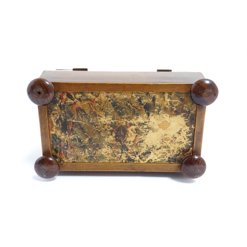 1248 - A late 19th / early 20thC burr walnut tea caddy of sarcophagus form with squat bun feet, opening to ... 