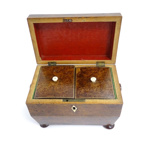 1248 - A late 19th / early 20thC burr walnut tea caddy of sarcophagus form with squat bun feet, opening to ... 