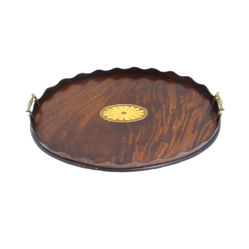 1262 - A Victorian mahogany tray of oval form with scalloped edge gallery, twin brass handles and inlaid sh... 