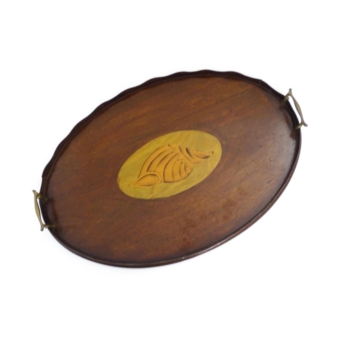 1262 - A Victorian mahogany tray of oval form with scalloped edge gallery, twin brass handles and inlaid sh... 